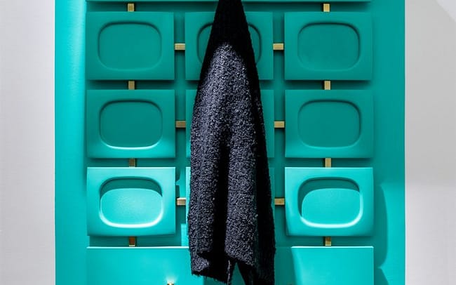 Ton in Ton. Second Hand Garderobe auf farbiger Wandfläche.