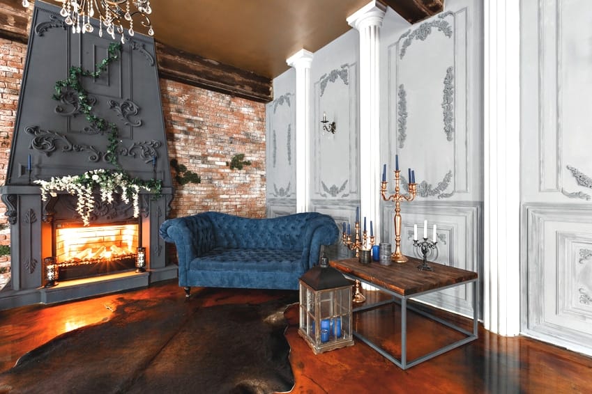 Kaminzimmer mit blauen Chesterfield Sofa und floralen Stuckornamanten